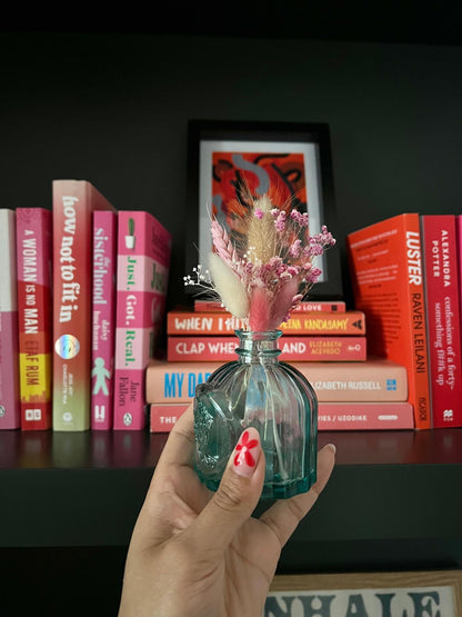 Handmade 'Welcome Baby Girl' card with dried flowers arranged in a removable slot. The flowers can be taken out and placed in a small vase, creating a lasting keepsake to celebrate the arrival of a baby girl.