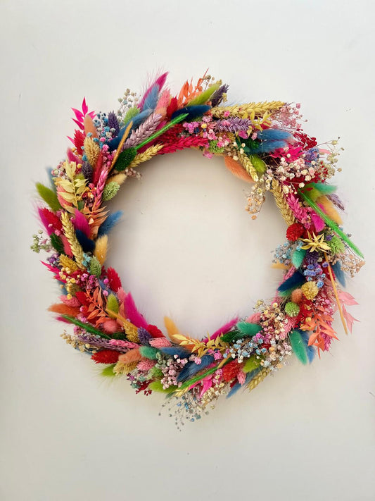 Colourful Christmas wreath with vibrant dried flowers, bringing festive cheer to any space.