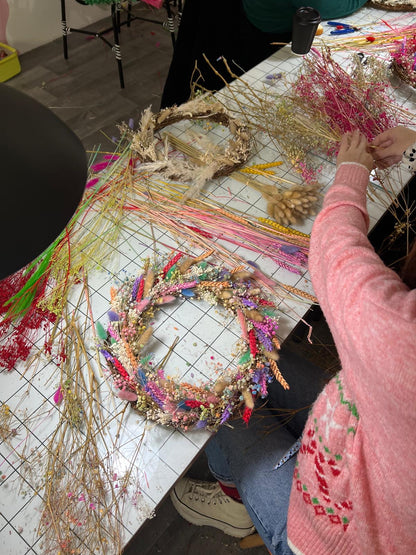 A woman in the process of crafting her 
own rainbow wreath made at a workshop hosted by The Flower Studio by Roo in Derby 