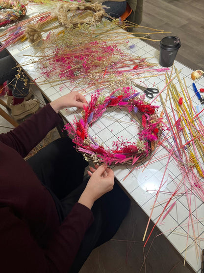 Someone holding their own crafted pink coloured wreath made at a workshop hosted by The Flower Studio by Roo in Derby and Birmingham 